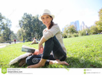 young-cheerful-woman-reading-book-sitting-central-park-new-york-city-guide-65090473.jpg