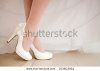 stock-photo-the-bride-shows-white-wedding-shoes-103603961.jpg