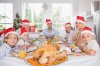 16228469-happy-family-wearing-santa-hats-around-the-dinner-table-at-christmas.jpg